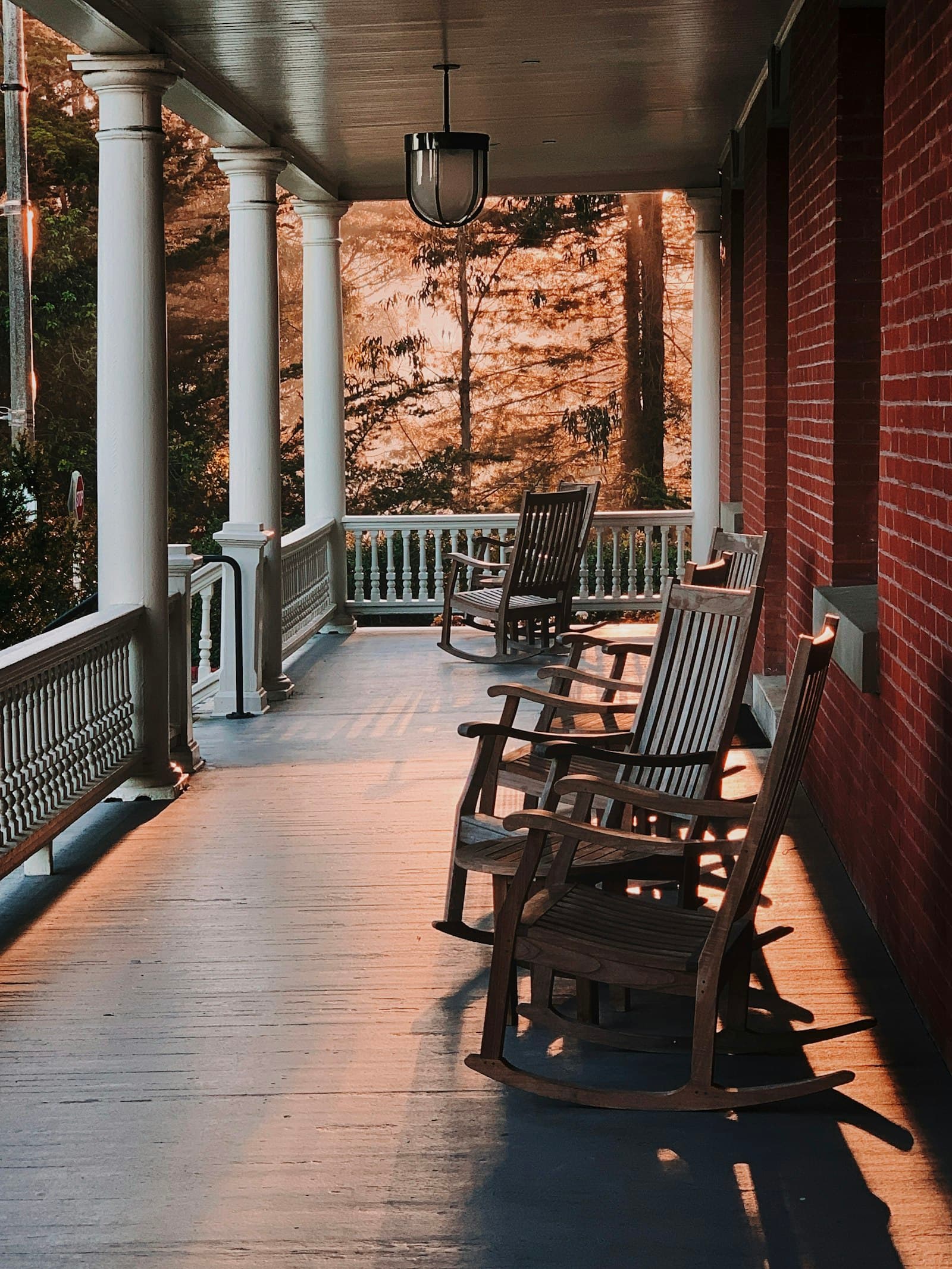 Rocking chairs on a covered front porch at golden hour